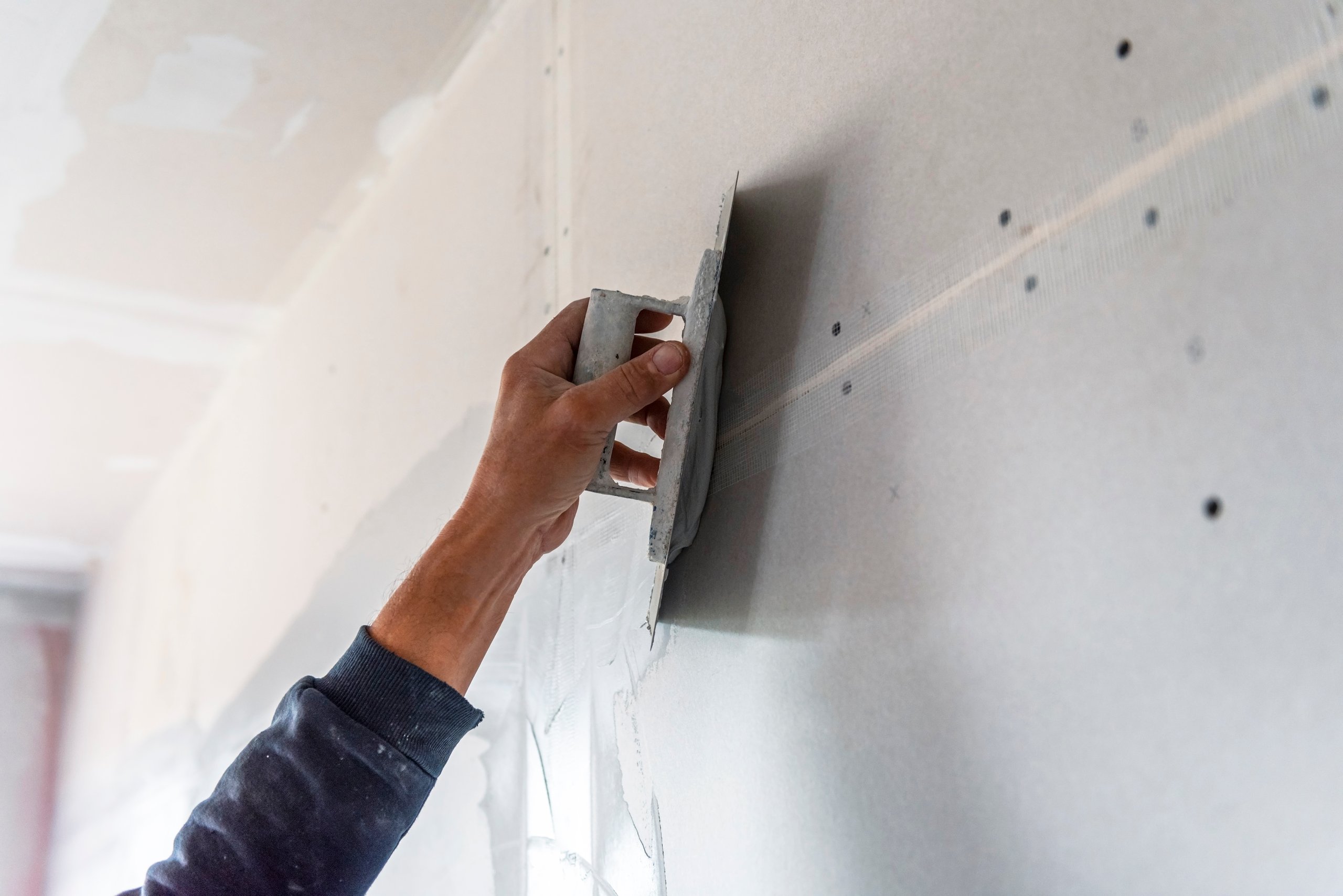 Stukadoor aan het werk met pleister en raapbord