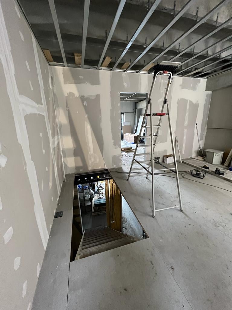 Construction site interior met gipswanden en ladder