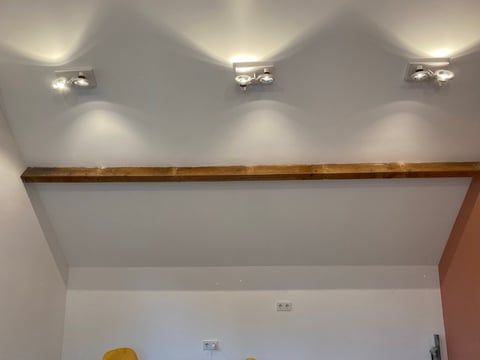Modern plafond met inbouwverlichting en houten rails