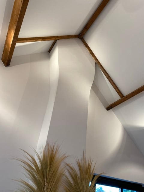 Wit gewelfd plafond met houten balken